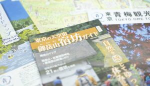 青梅市観光協会が発行する、「東京の天空宿 御岳山宿坊ガイド」などの観光パンフレットが机に置かれた写真