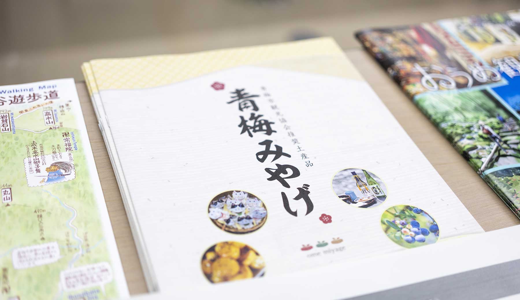 青梅市観光協会が発行する、「青梅みやげ」パンフレットが机に置かれた写真