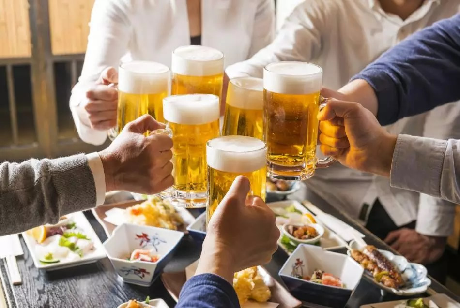 Raising glasses at an izakaya