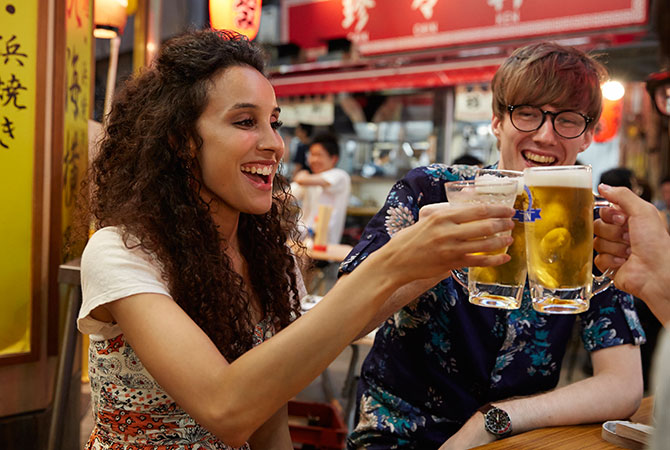 Touristes étrangers passant un bon moment à un bistrot izakaya